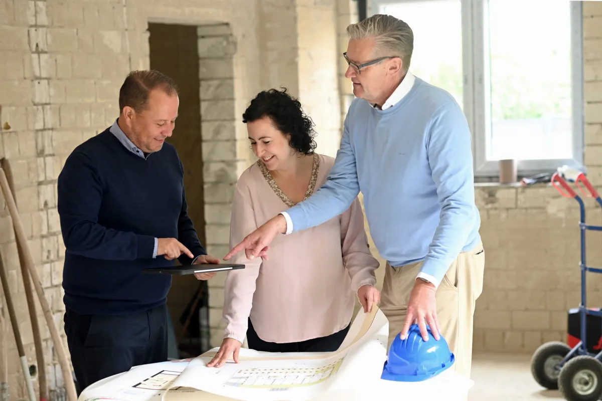 Zwei Männer und eine Frau auf einer Baustelle
